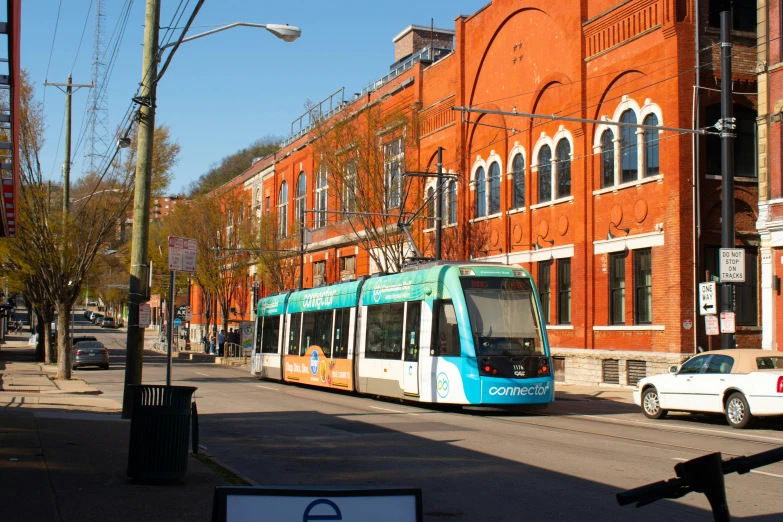 an electric train on the tracks with the city bus in front