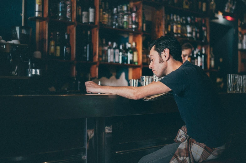 a man leans over a bar as he looks away