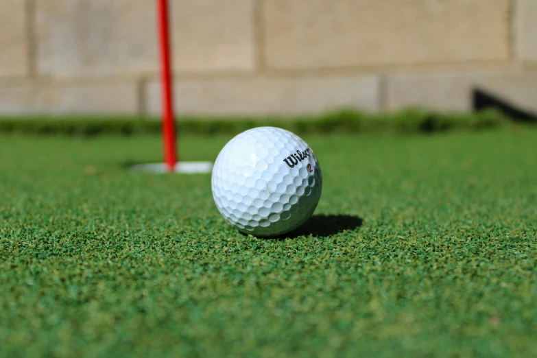 a white golf ball on the green grass