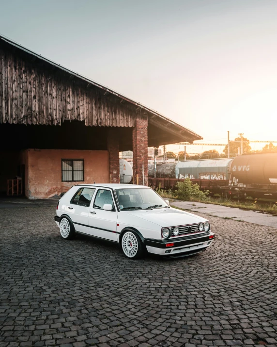 a white car parked outside of a large building