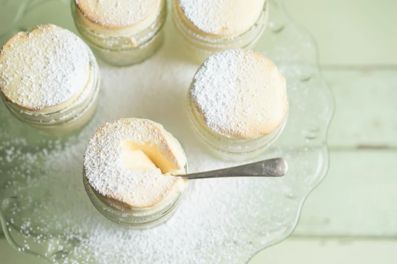 some mini cakes on a glass plate with a spoon