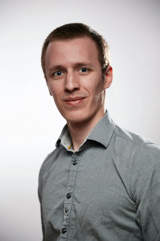 a male wearing a grey shirt and green tie