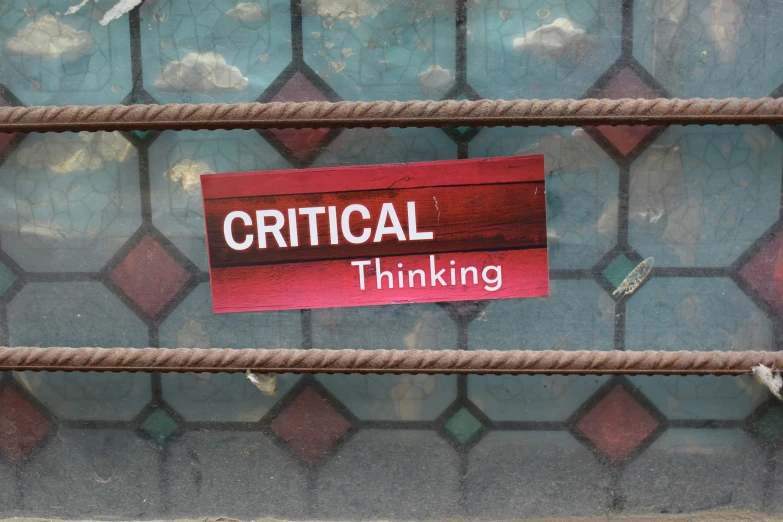 a sign on the side of a fence that says critical thinking