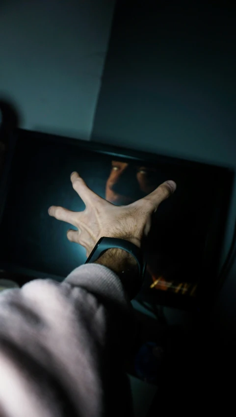 a hand reaching for an item on the television