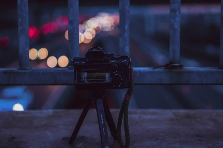 a camera on a tripod sitting on the side of a building at night