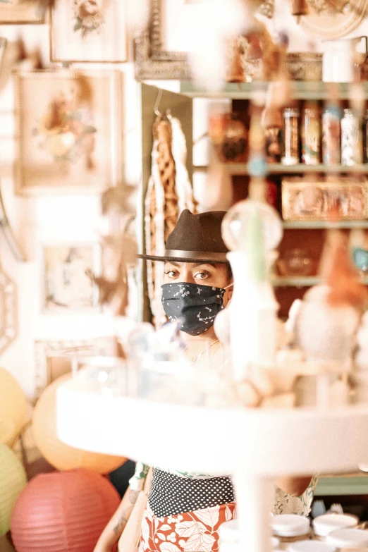 woman standing in the mirror wearing black mask and hat