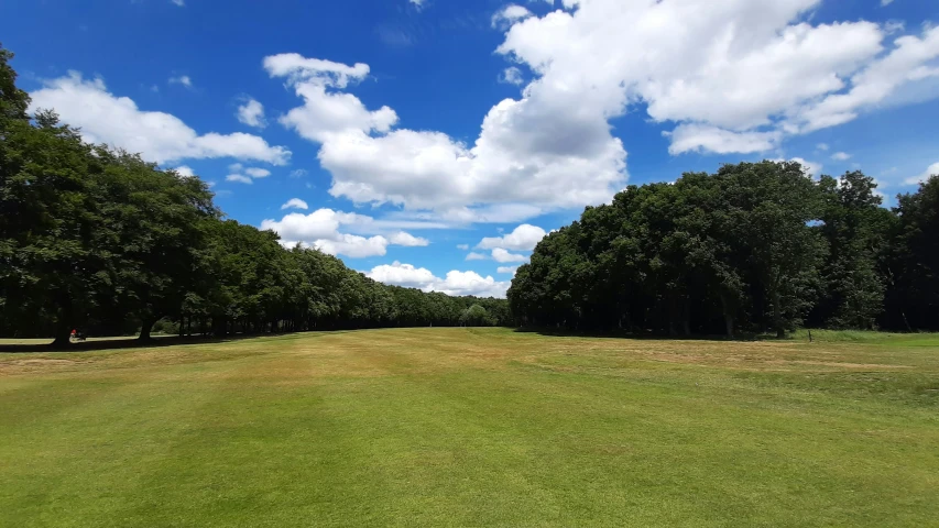 a sunny day at the golf course with some blue skies