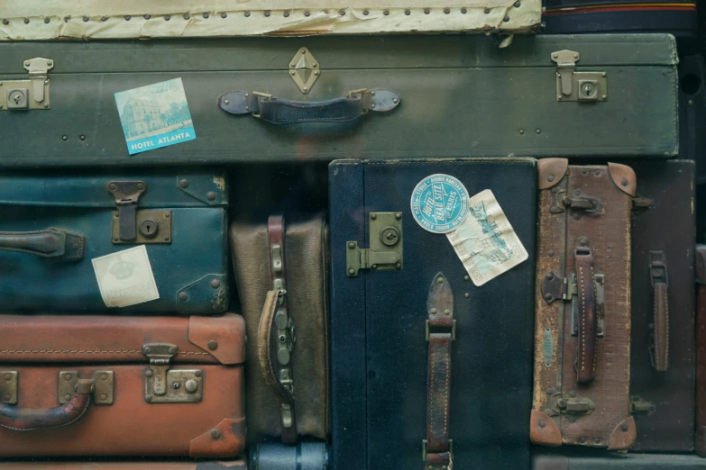 a pile of old suitcases that are brown and green