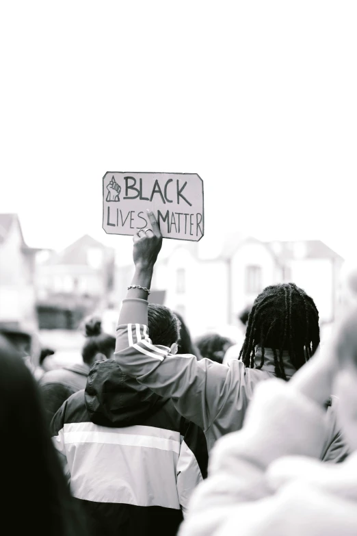 a man holding a sign that says black lives matter