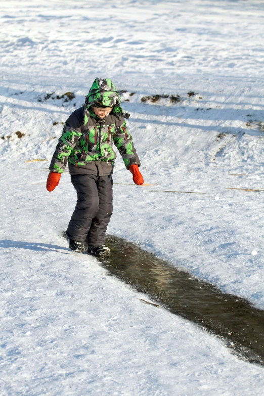 a child riding skis down a snow covered slope