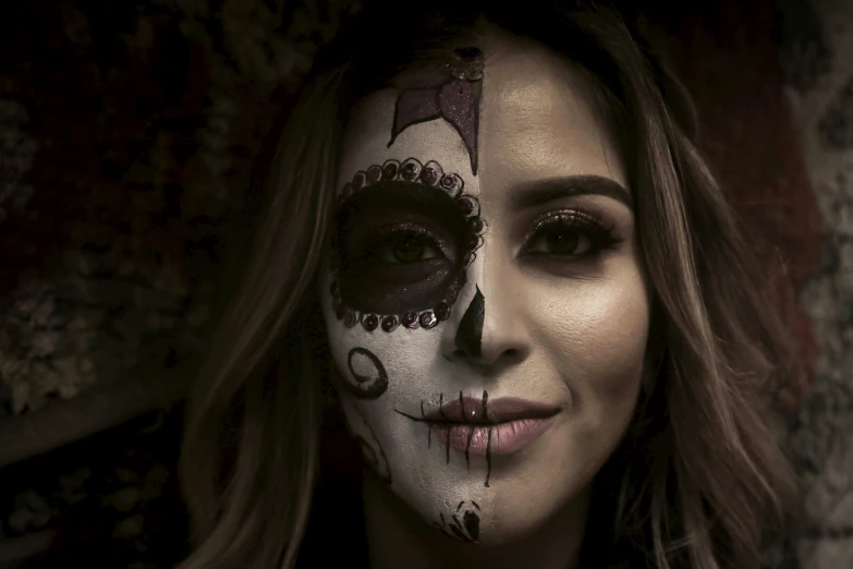 a beautiful young woman wearing a scary skull make up