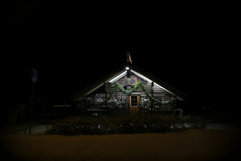 a lighted building with a wreath on it in the dark