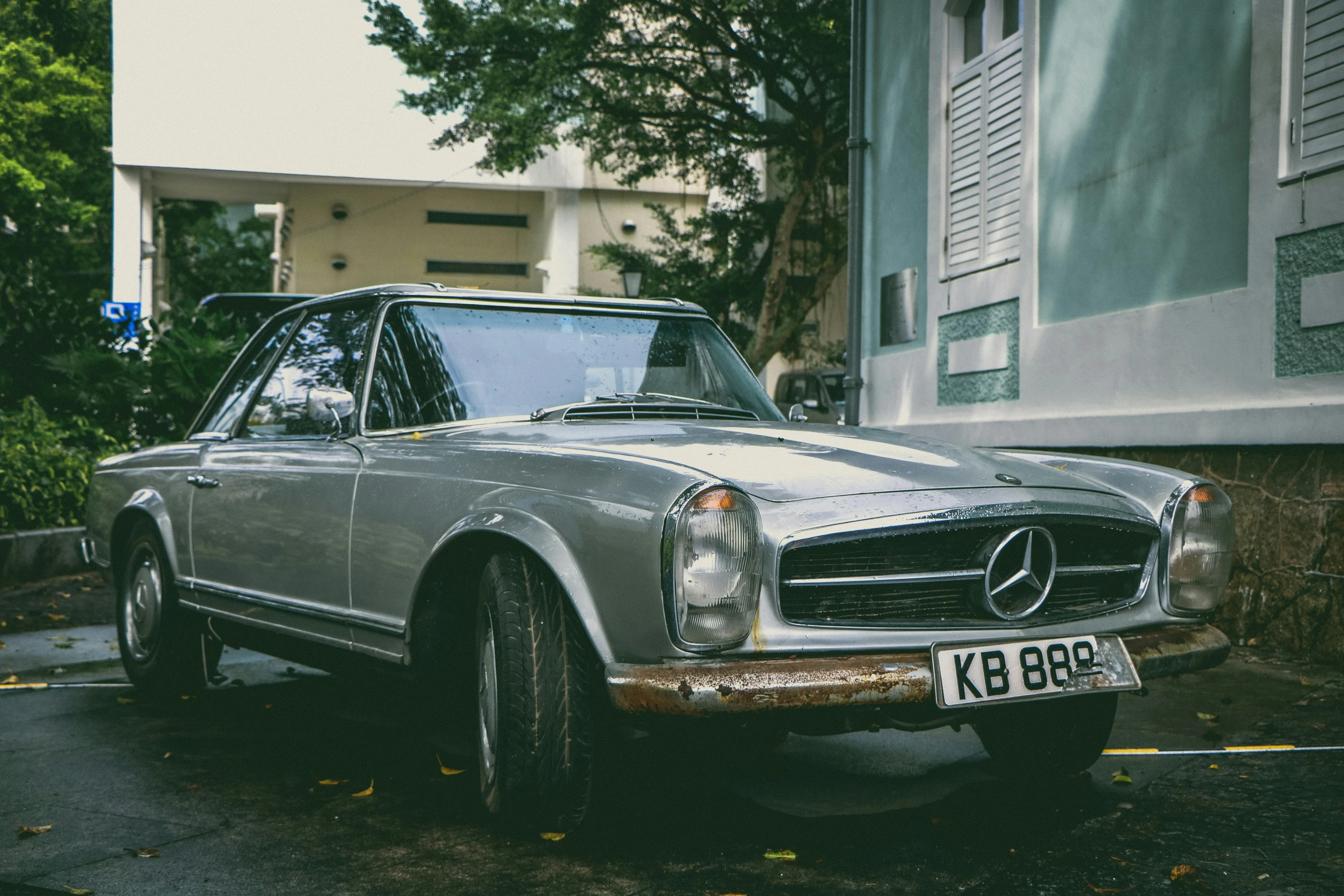 an old mercedes benz parked on the side of a road