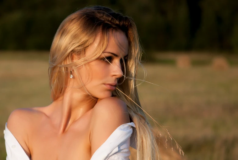 a beautiful blonde haired woman in a field