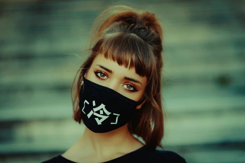 a woman wearing a face mask with white letters