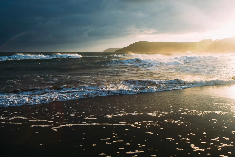 there is an ocean with waves crashing on the beach