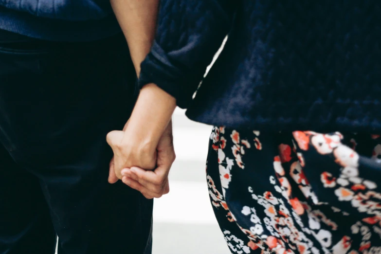 two people holding hands in the street