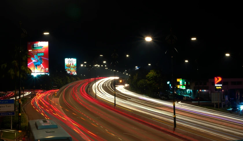 cars passing at night with blurred traffic on a city street