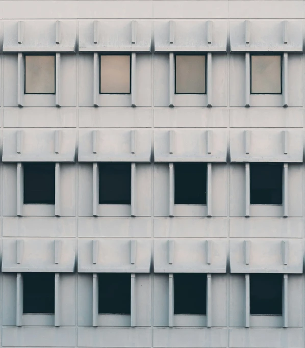 an architectural concrete building with five windows and no blinds