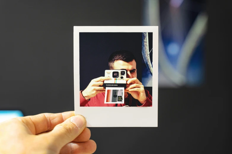 person holding up a polaroid in their hand with the lens