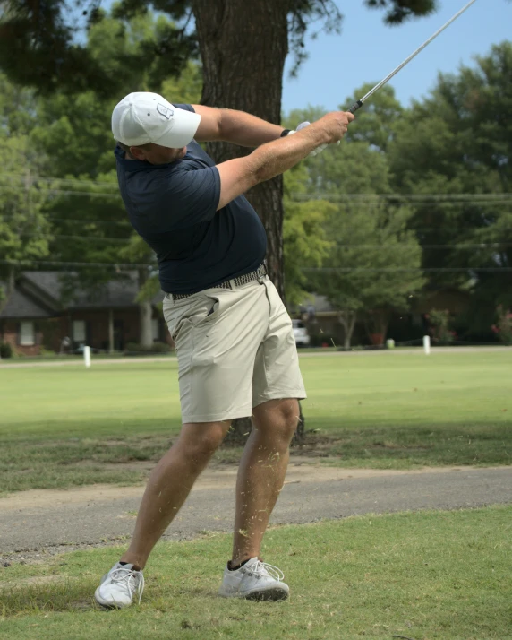 a man who is standing in the grass swinging his golf club