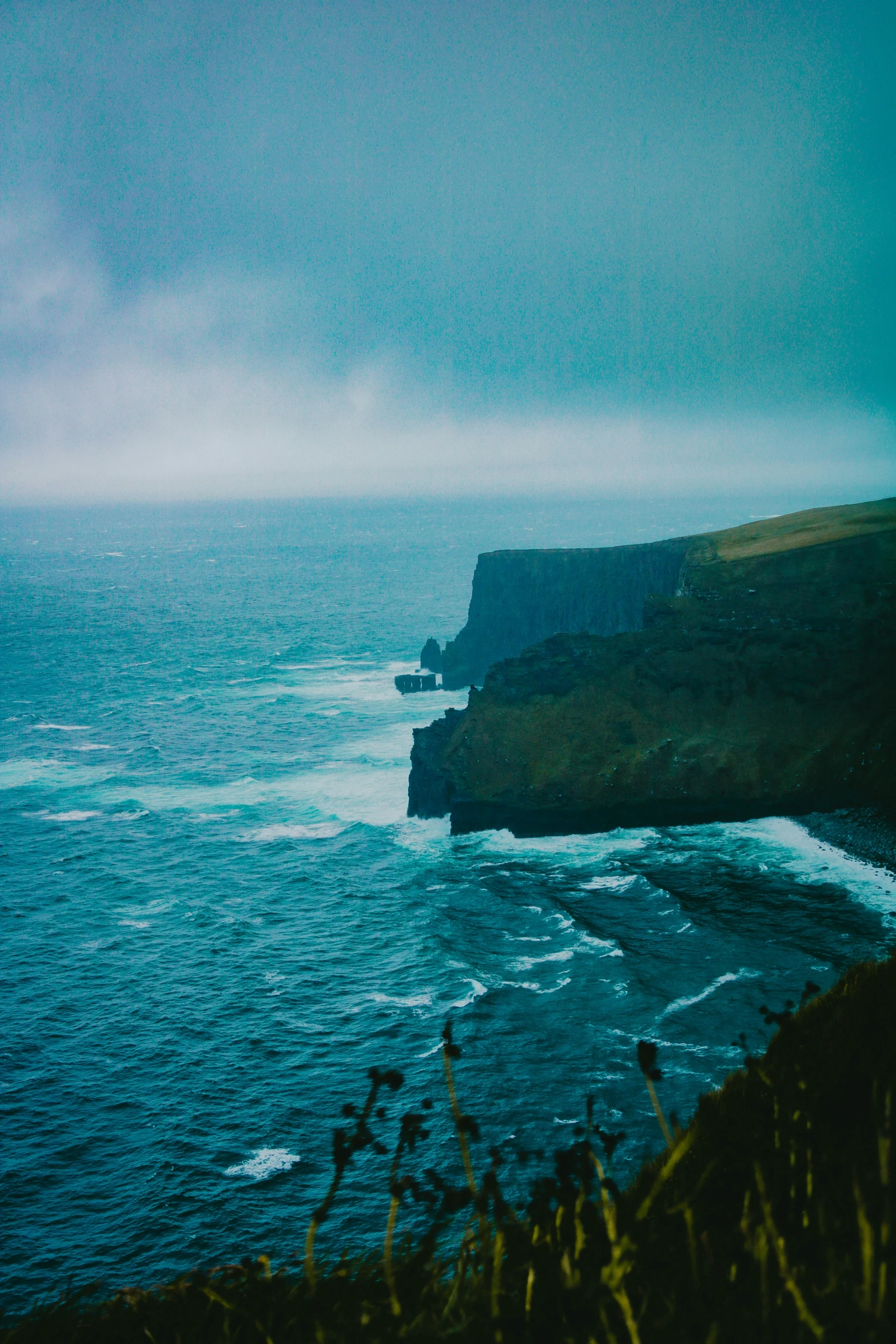 a person is parasailing in the ocean on a hill top