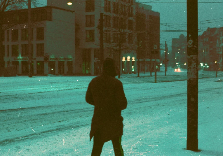 person walking across snowy street with the snow covering