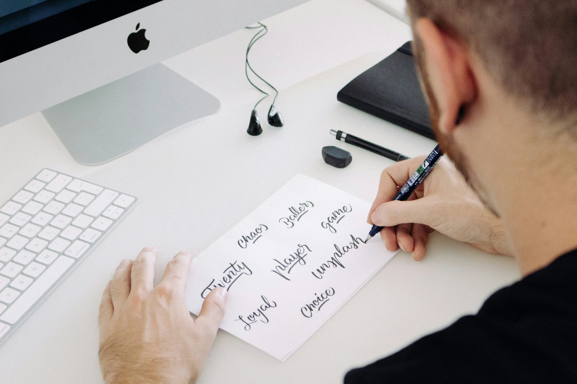 person writing on a note on a computer keyboard