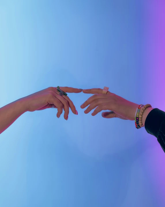 the hands of two people reaching for each other