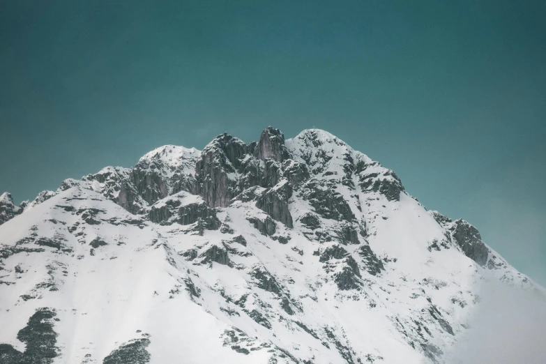 the top of a snowy mountain against a blue sky