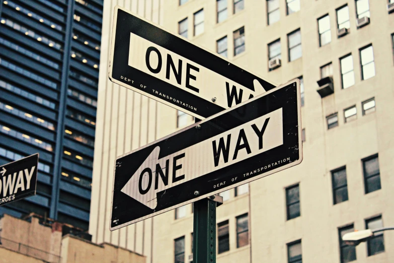 two street signs pointing in opposite directions near tall buildings