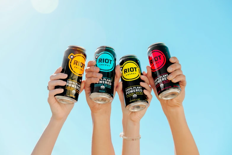 four people holding up various flavored drinks in their hands