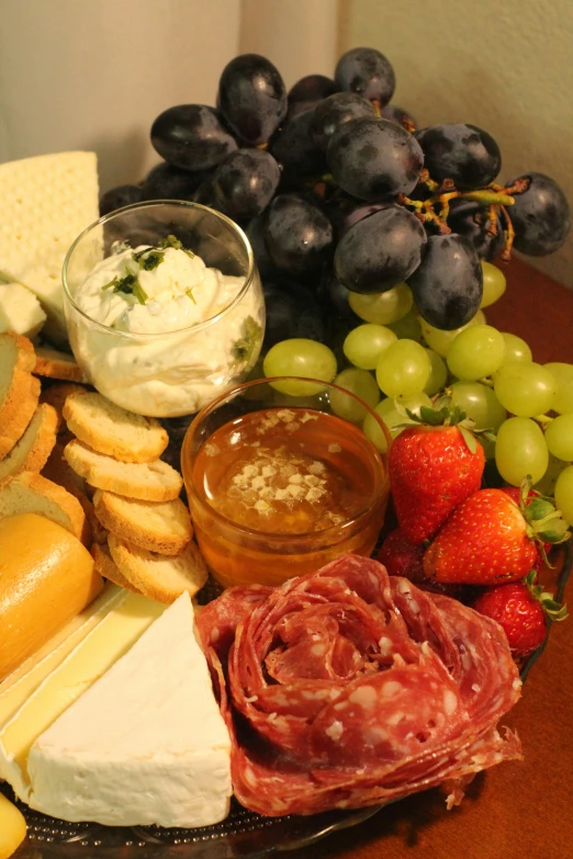 a display of cheese and fruit in front of gs