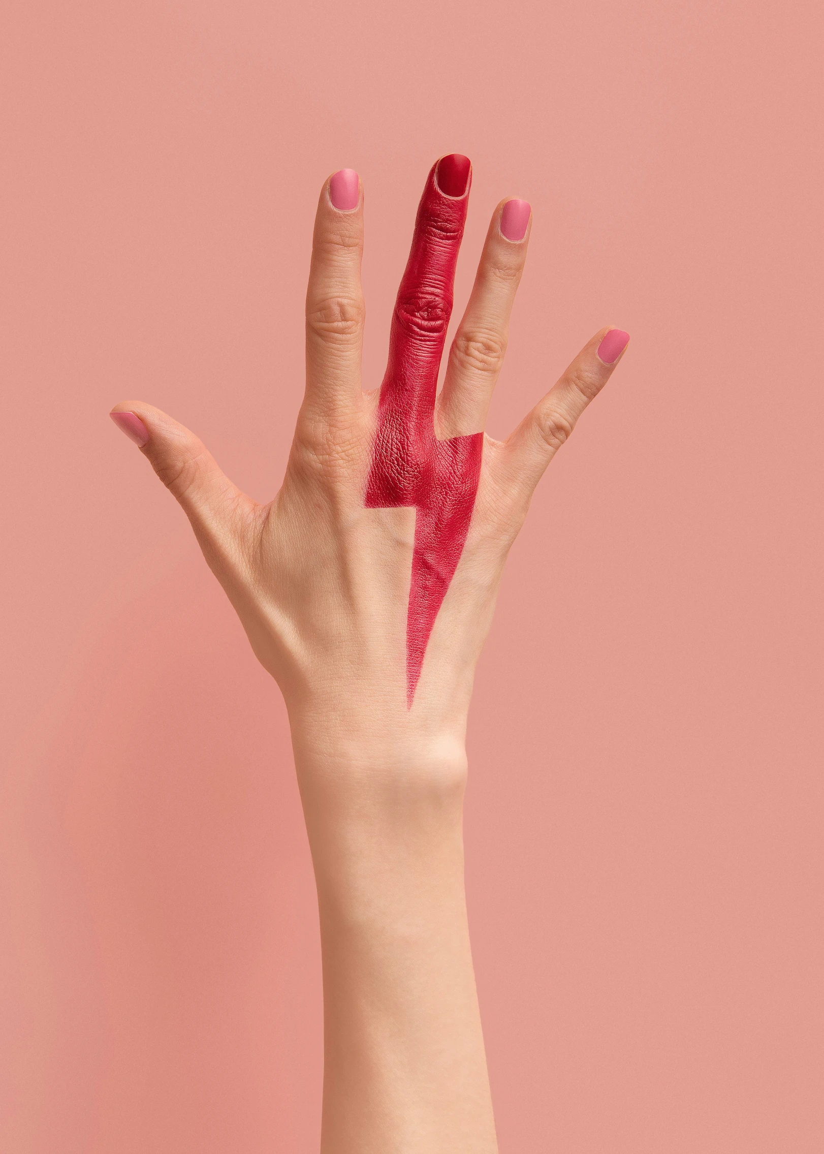 a hand is holding red glittered nail and pointing at the camera