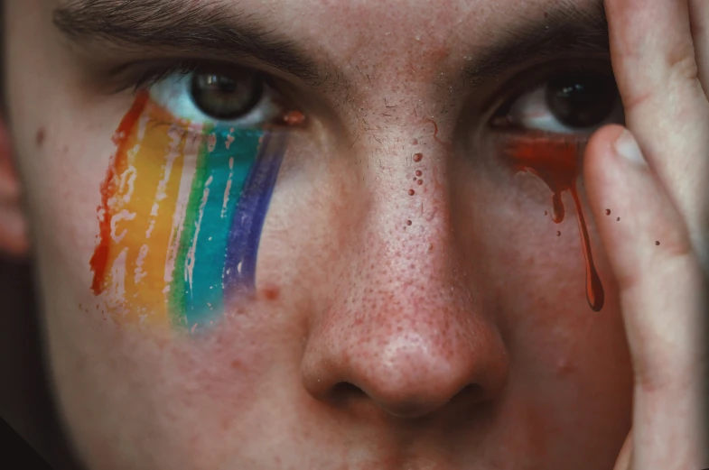 a close up of a person's face painted with different colors