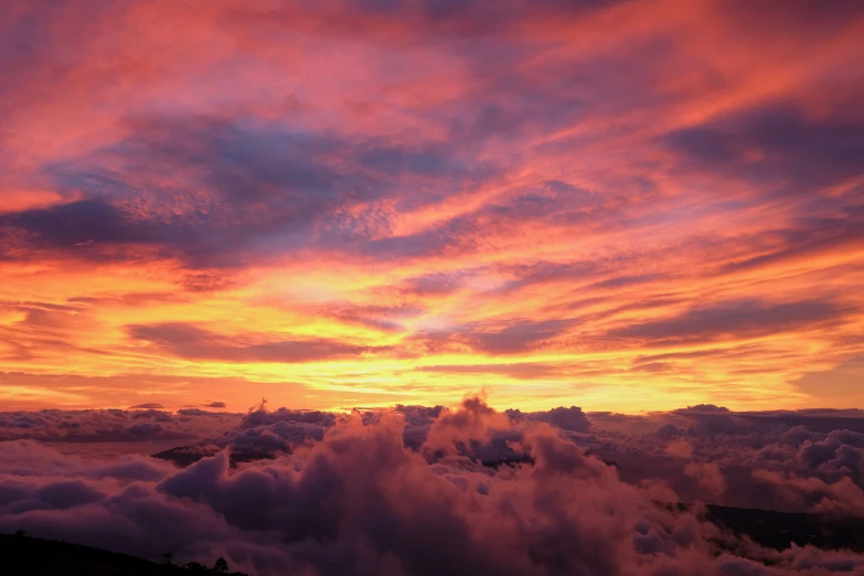 a sunset above the clouds over a valley