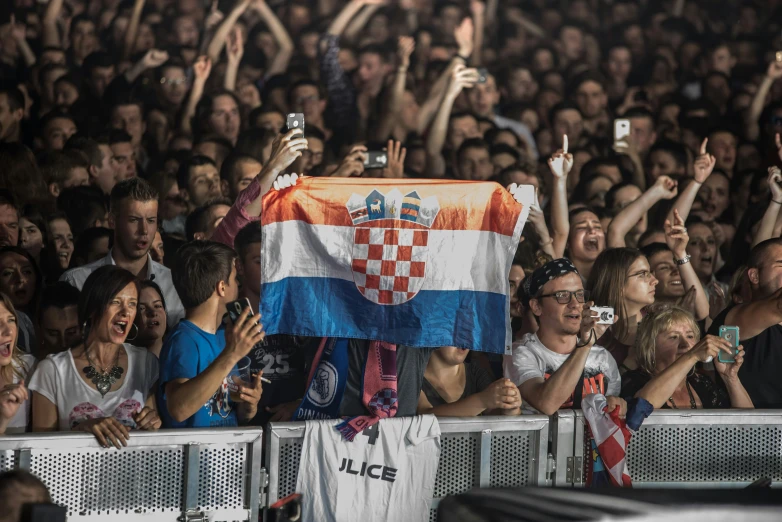 people are cheering and holding up a flag