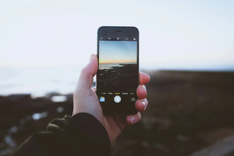 the person is holding up his cell phone