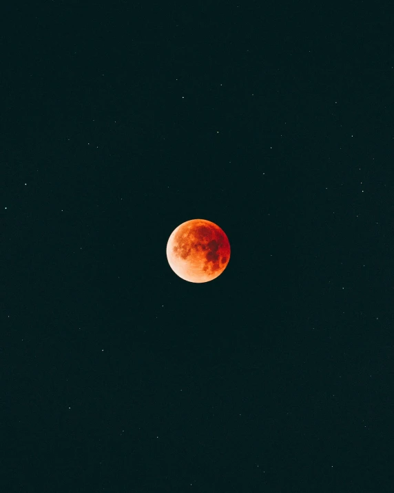 a red moon is seen in the sky