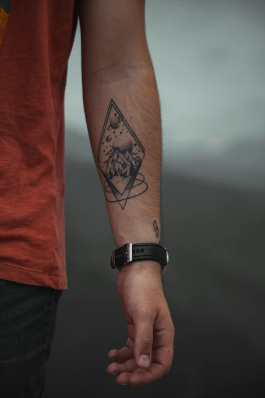 a person with a tattoo on his arm and celet