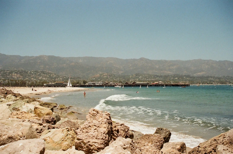 the beach has two surfers standing in the water