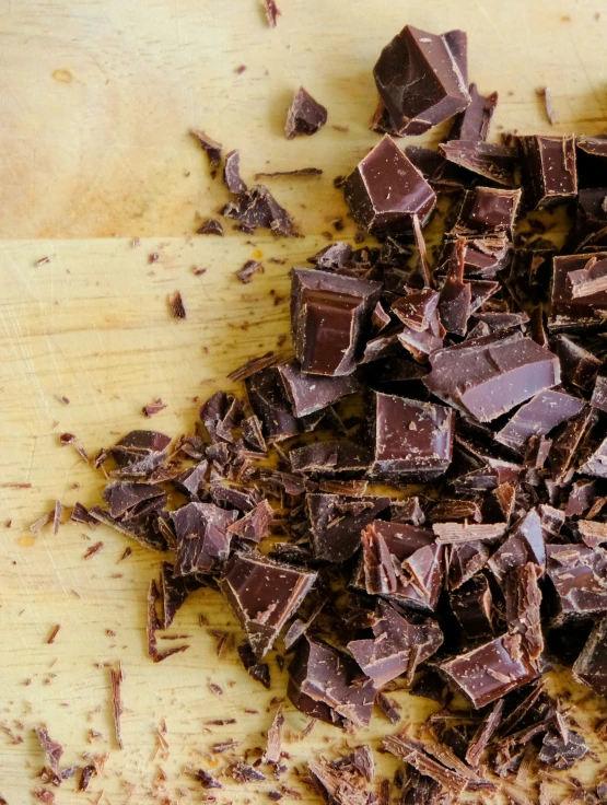 a wooden  board topped with chunks of chocolate