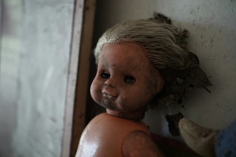 a dirty doll hanging against the wall with the clothes pulled back