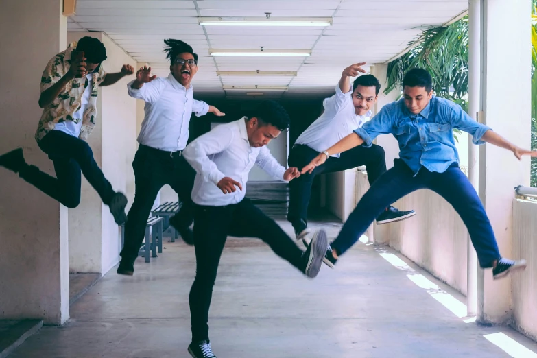 six men wearing white shirts are jumping high up into the air