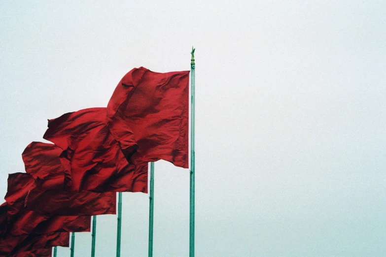 a group of red flags fly in a group