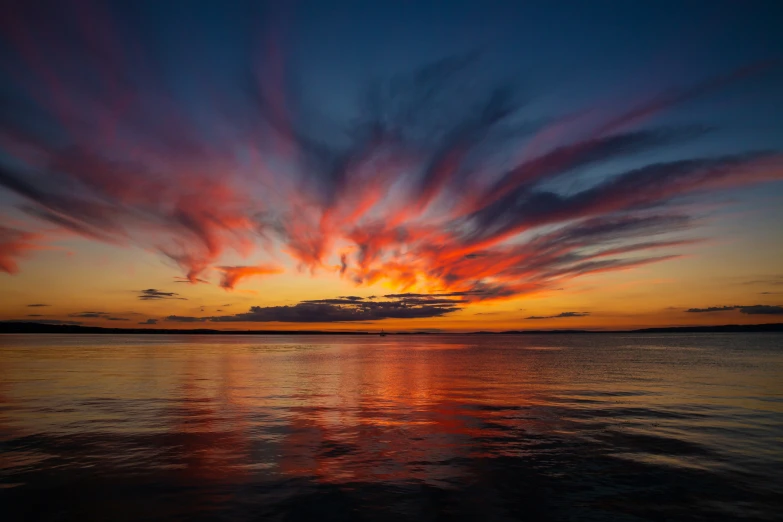 the sunset is reflecting off the water in the dark