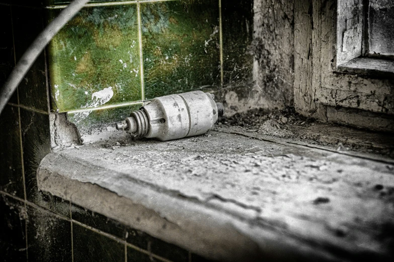 old and damaged bathroom with water bottle on the edge