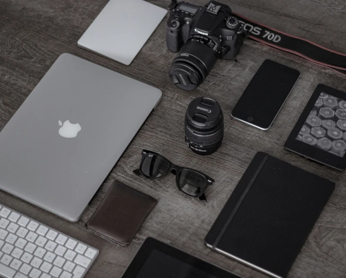 a computer, camera and other things sitting on the ground