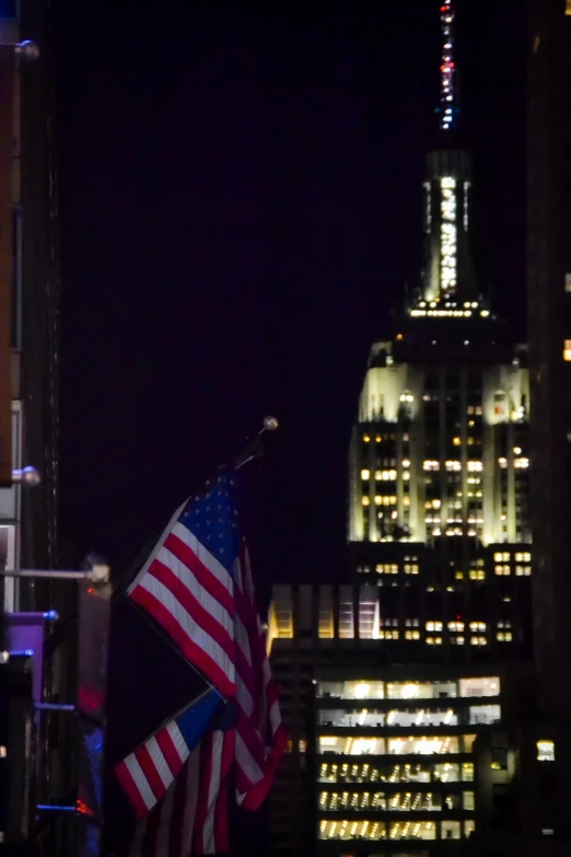 a flag is flying in front of a tall building