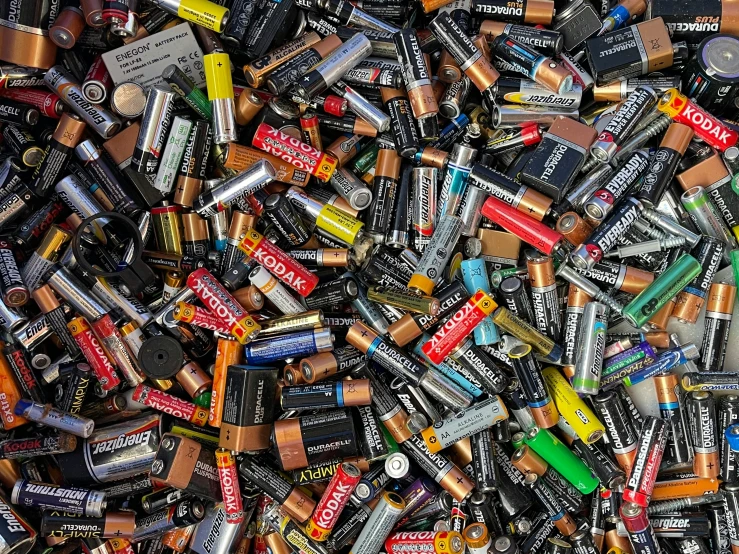 various batteries and batteries are scattered on a white table